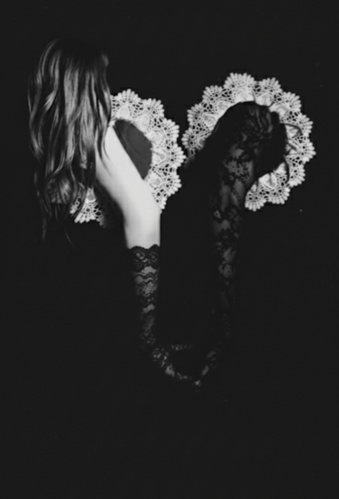 Black and white photo of a person with floral headpieces on a black background