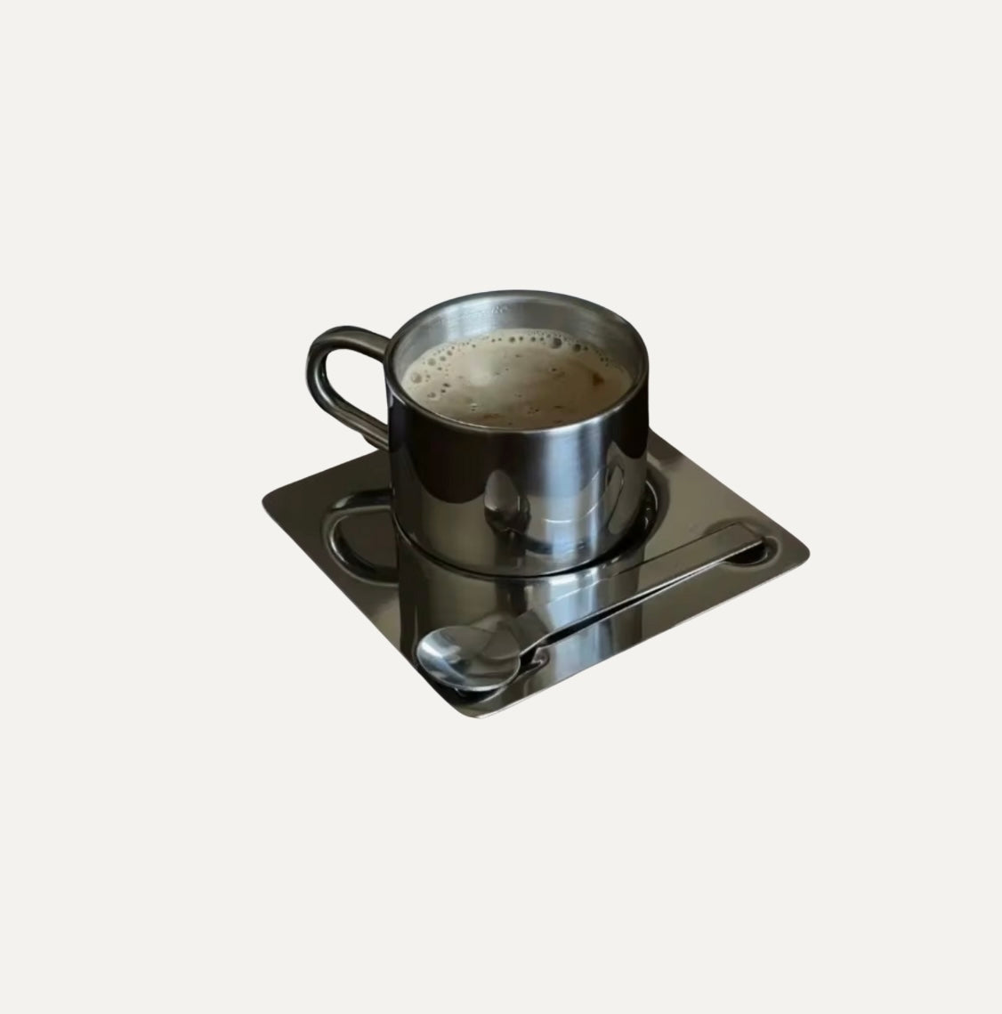 Metal cup with saucer and spoon on a white background